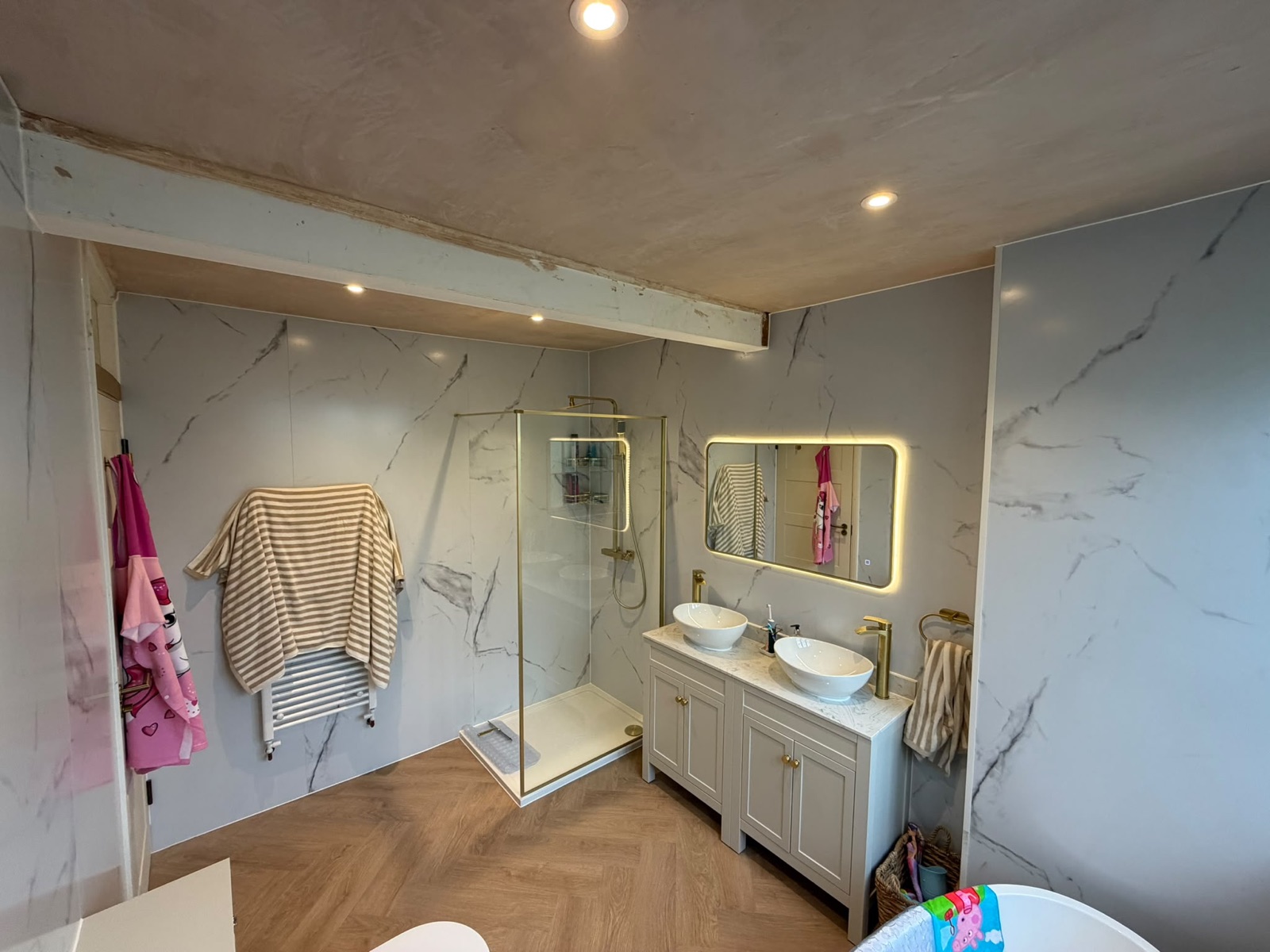 Marble bathroom with backlit mirror and walk-in shower